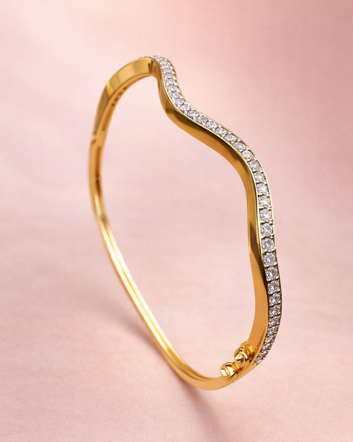 Gold bracelet with diamond accents on a pink background