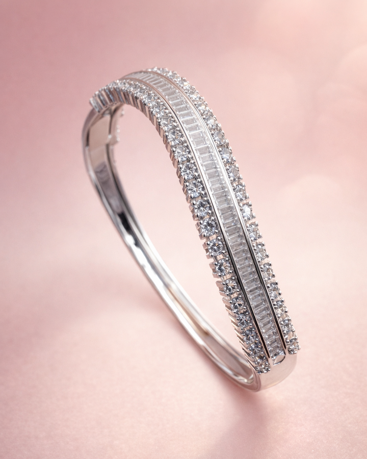 Silver bracelet with diamond accents on a pink background