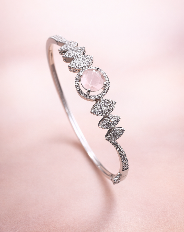 Silver bracelet with a pink gemstone on a soft pink background