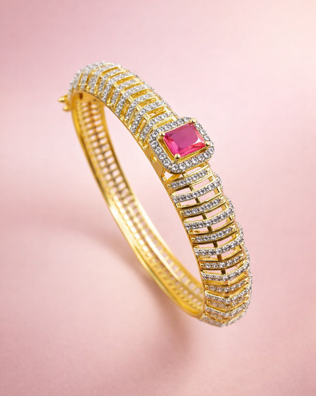Gold bracelet with a pink gemstone on a pink background