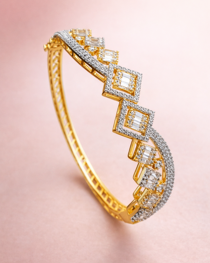 Gold bracelet with diamond accents on a pink background