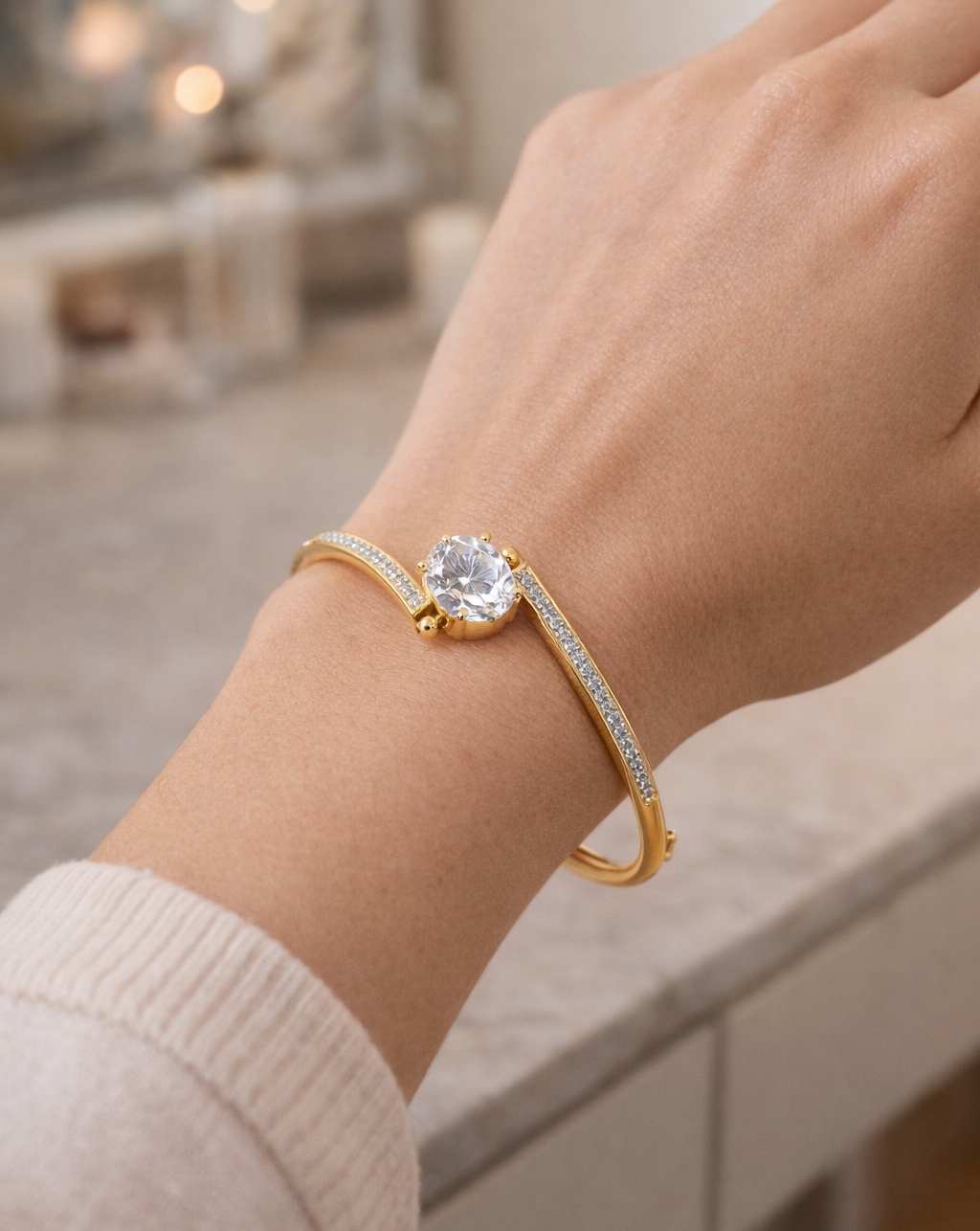 Gold bracelet with a diamond on a wrist, blurred background