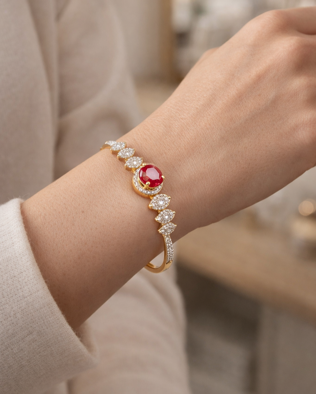Jeweled bracelet with a red gemstone on a wrist, blurred background
