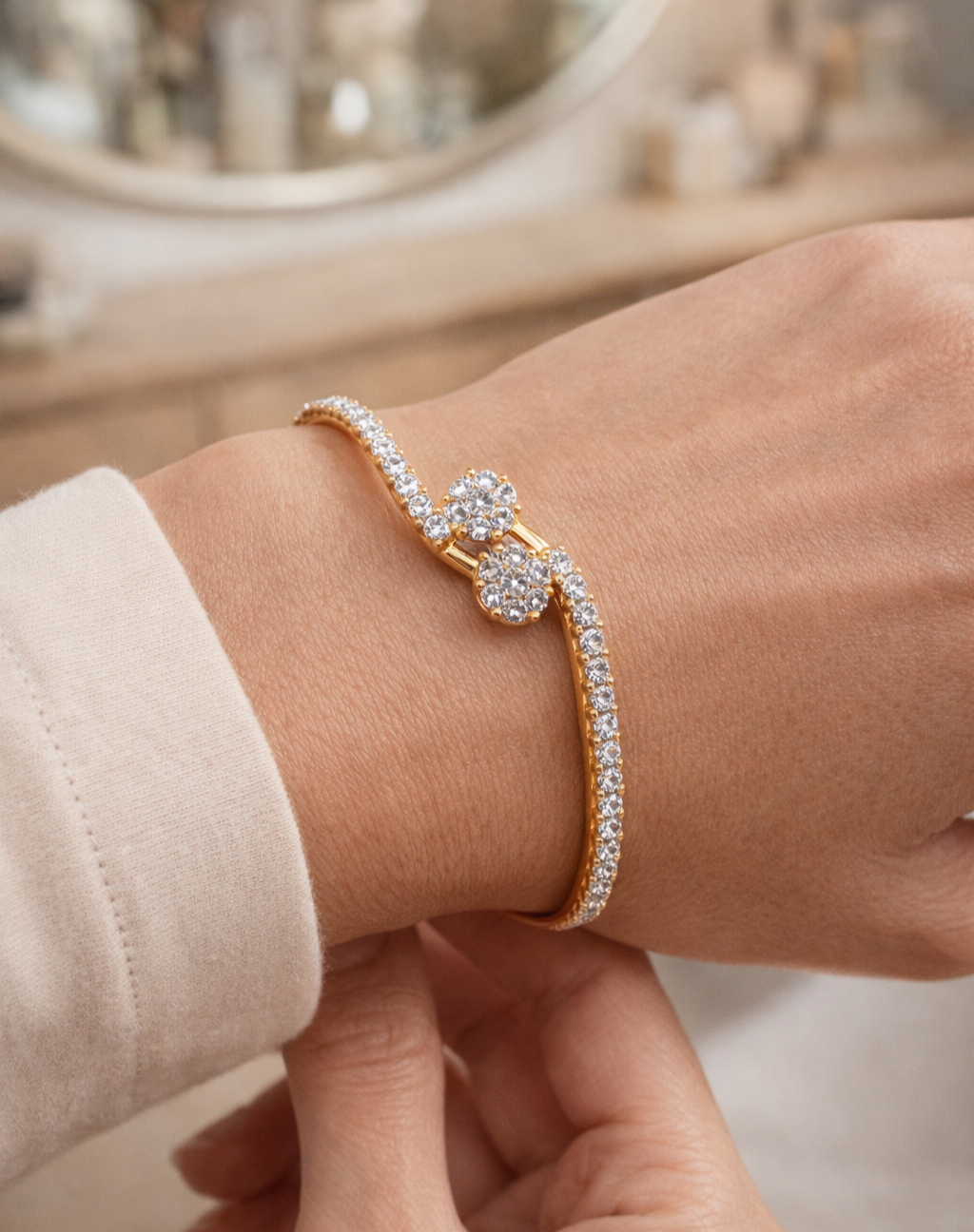 Gold bracelet with diamond accents on a wrist against a neutral background