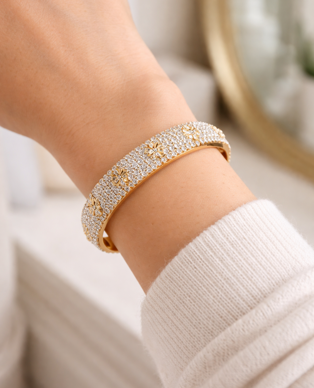 Gold bracelet with clear stones on a wrist against a blurred background