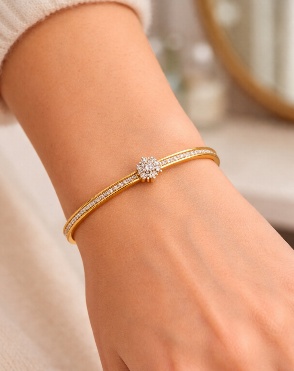 Gold bracelet with a diamond clasp on a wrist against a blurred background
