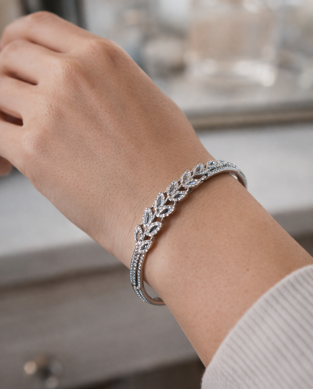 Silver bracelet on a wrist with a blurred background