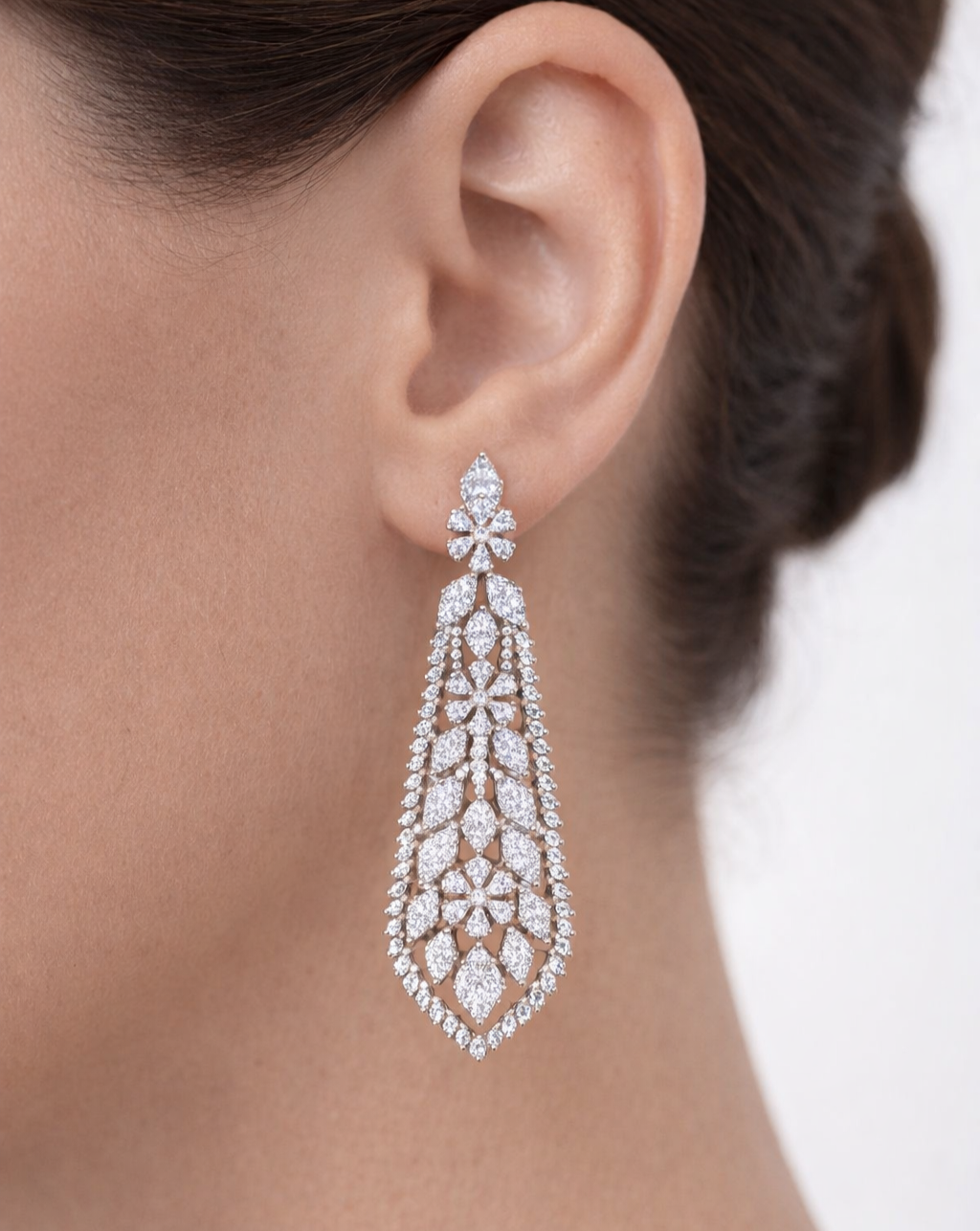 Close-up of a diamond earring on an ear with a blurred background