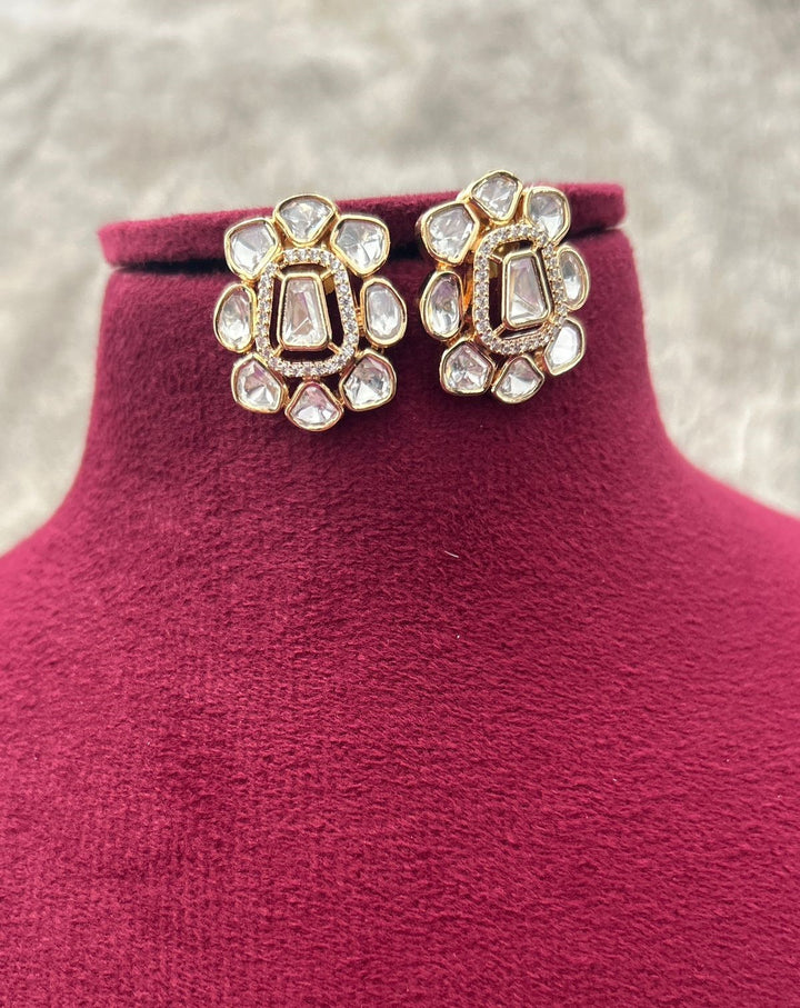 Decorative earrings on a mannequin with a textured background