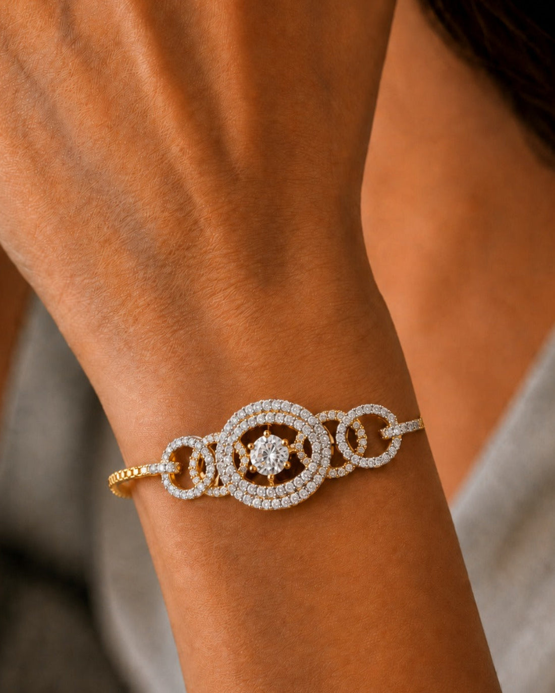 A close-up of a gold and white gold bracelet with pavé-set diamonds worn on a person's wrist.