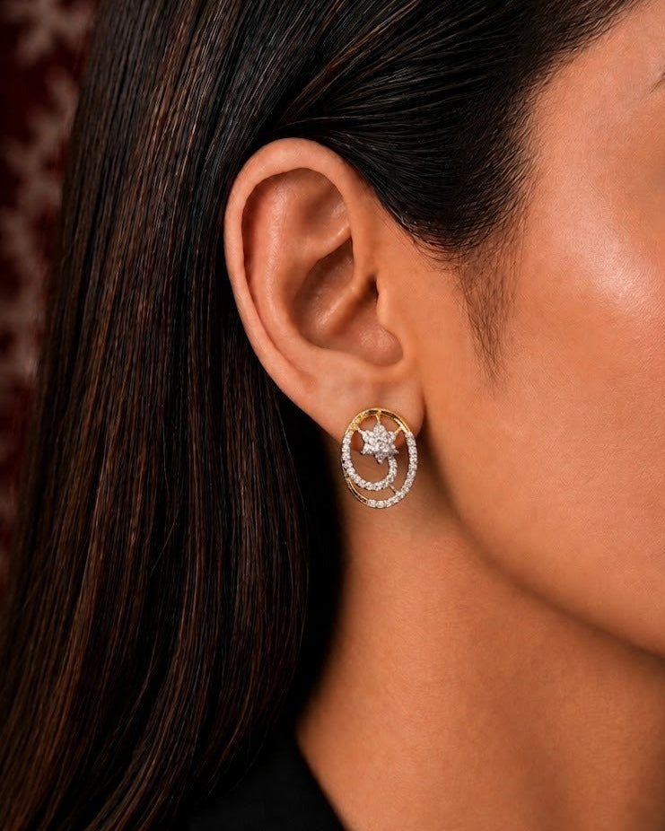 A close-up side profile of a woman wearing a gold and silver crescent moon stud earring with a central star detail.