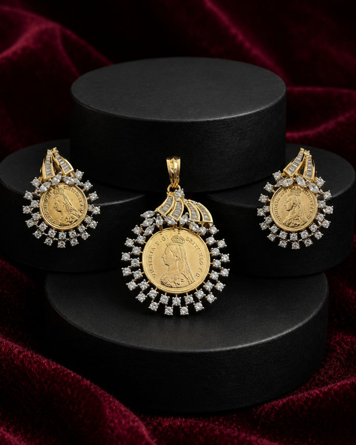 A gold coin pendant necklace with diamond accents, displayed alongside matching earrings on black cylindrical pedestals against a dark red velvet background.