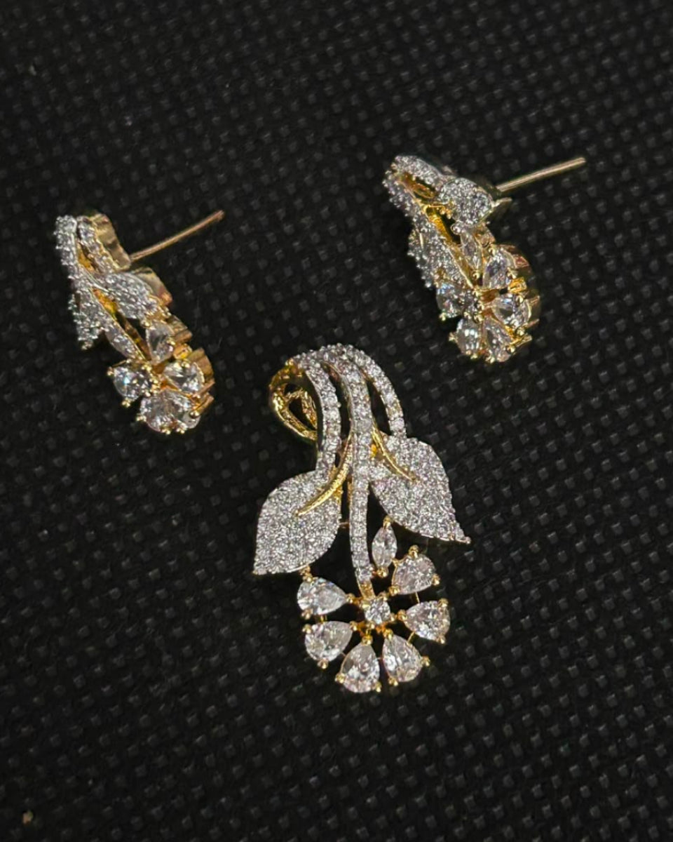 A pair of gold and diamond floral stud earrings displayed on a textured black background.