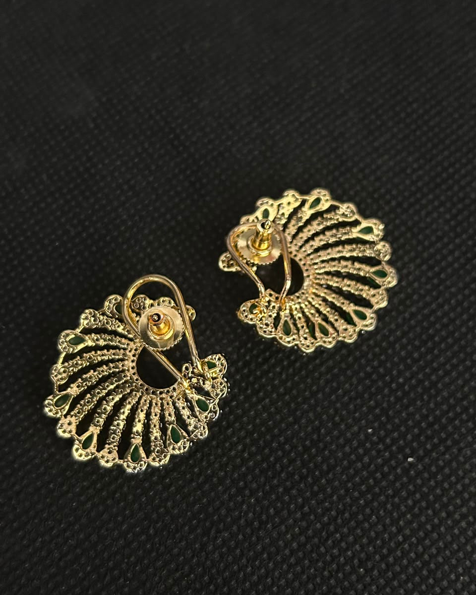 A pair of gold-toned filigree clip-on earrings with a fan-like openwork design and a small central gold accent, displayed on a textured black background.
