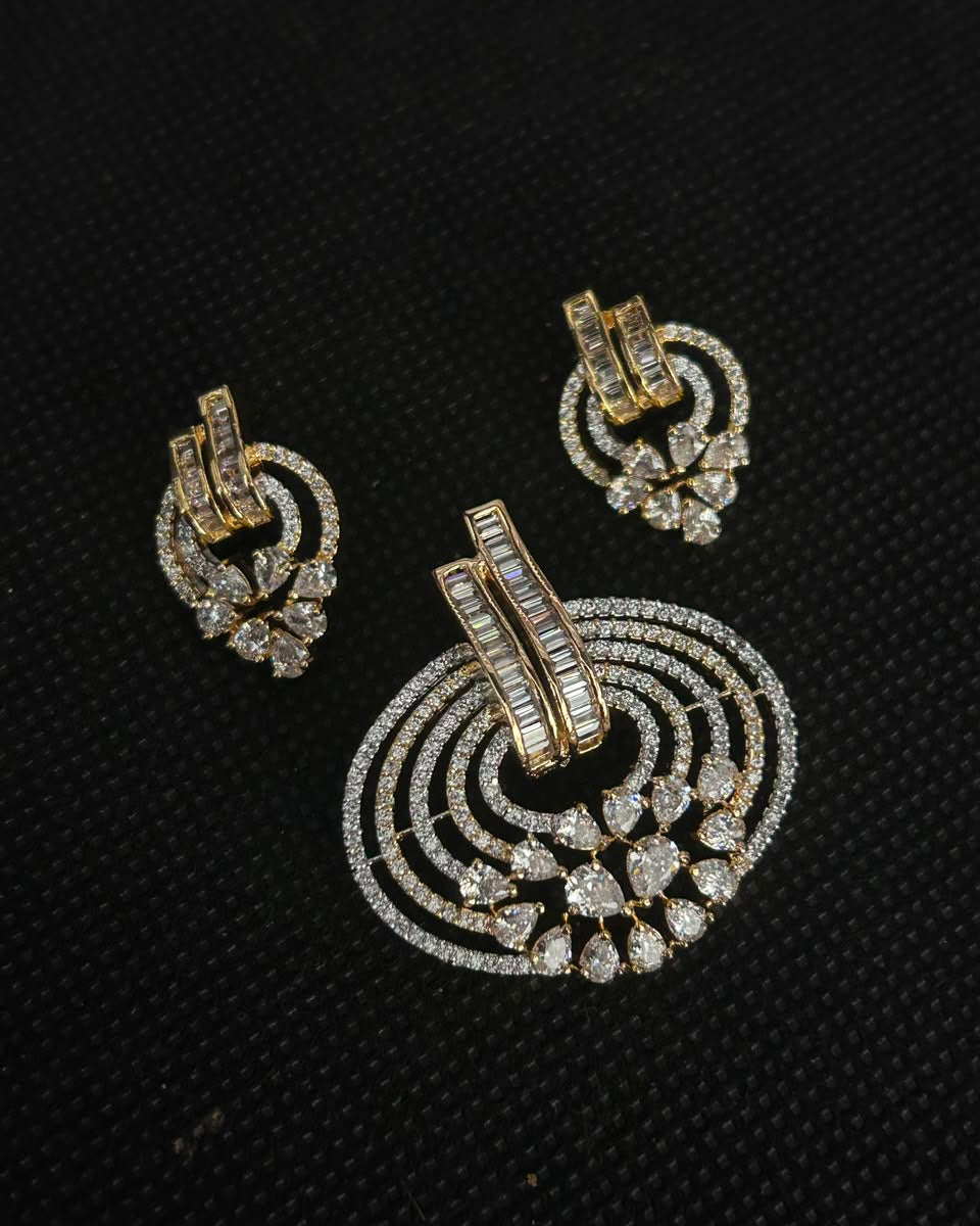 A pair of gold-toned traditional Indian earrings with intricate diamond and crystal work, displayed on a textured black background.