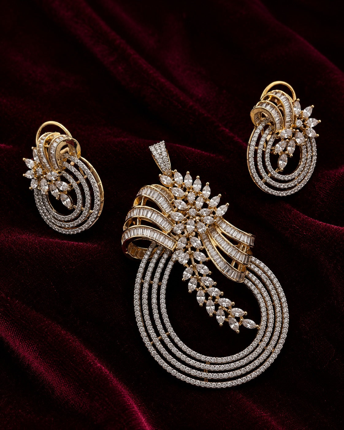 An ornate gold jewelry set featuring a large pendant, matching earrings, and a slim bracelet, all adorned with sparkling clear stones and set against a dark red velvet background.