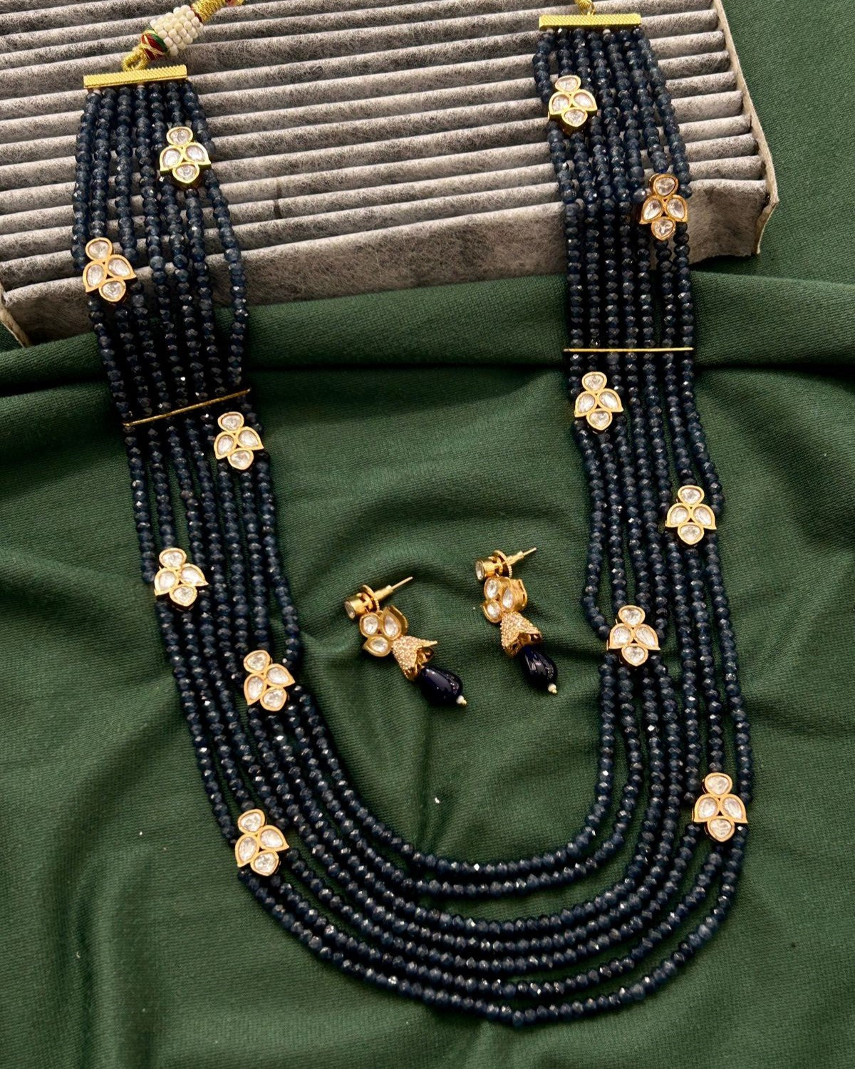 Elegant necklace and earring set highlighted by rich navy bead detailing
