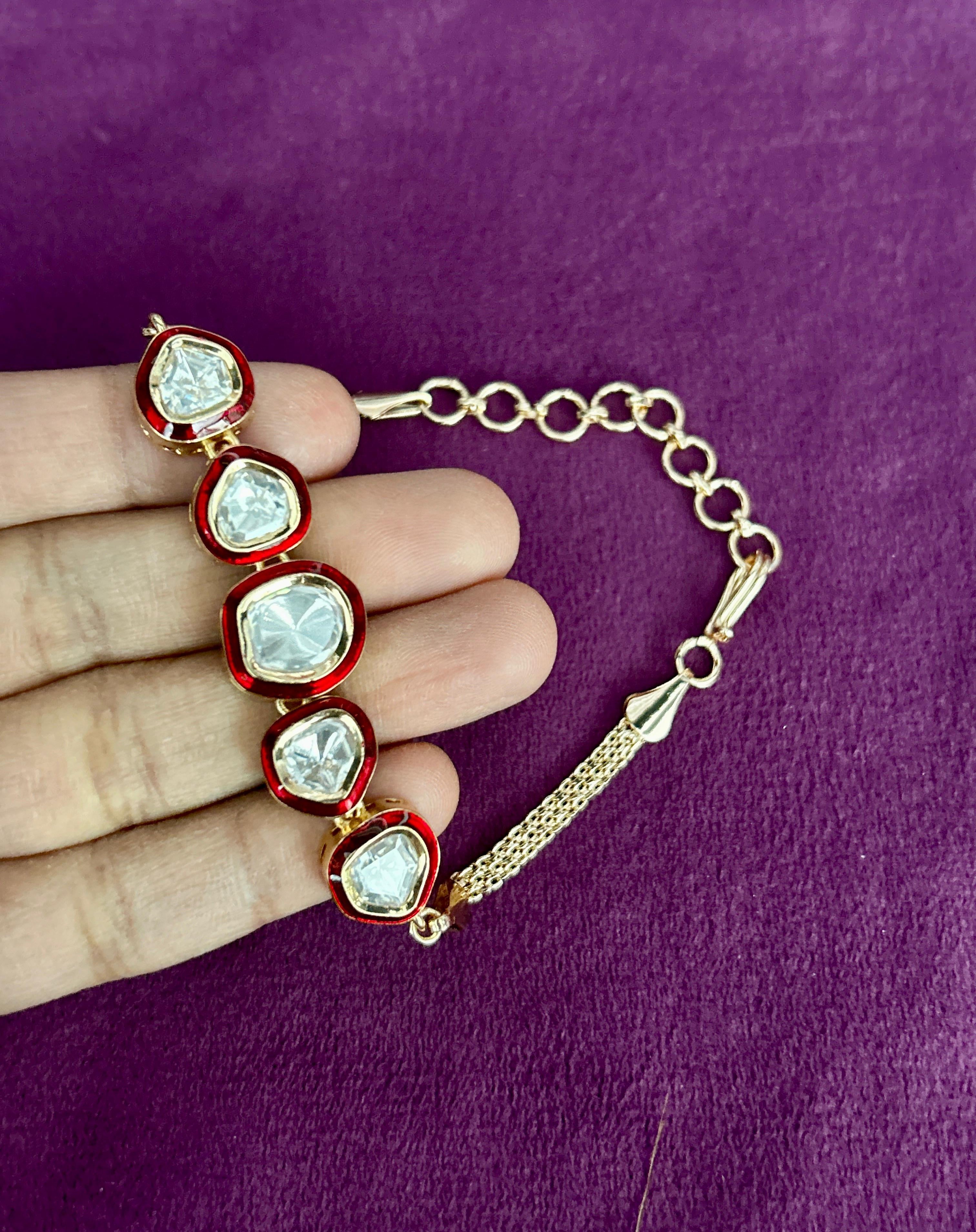Bracelet with heart-shaped gemstones held by a hand on a purple background