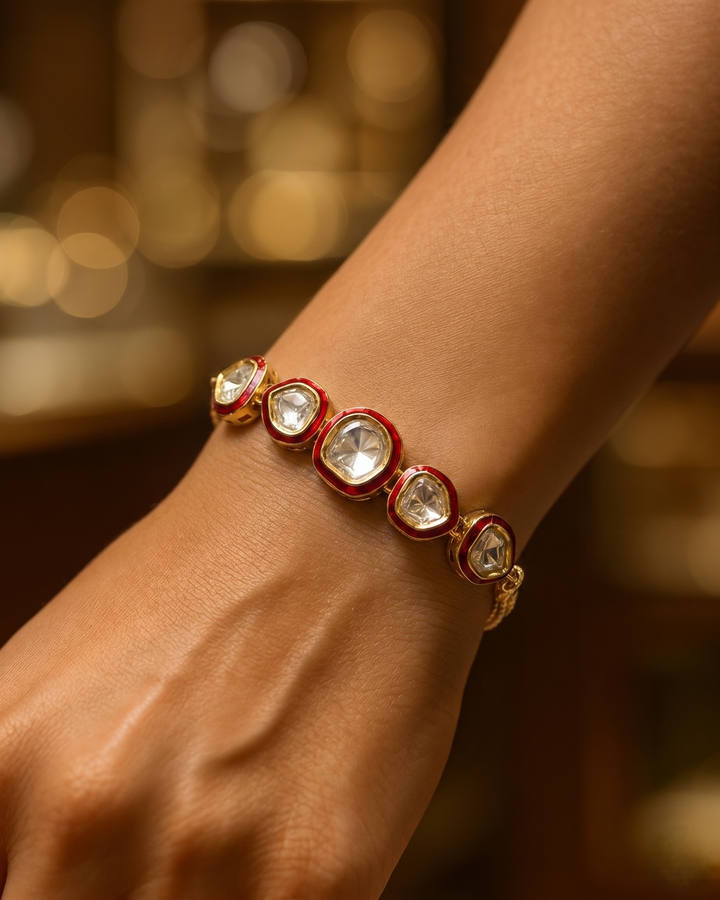 Bracelet with red and gold accents on a wrist against a blurred background