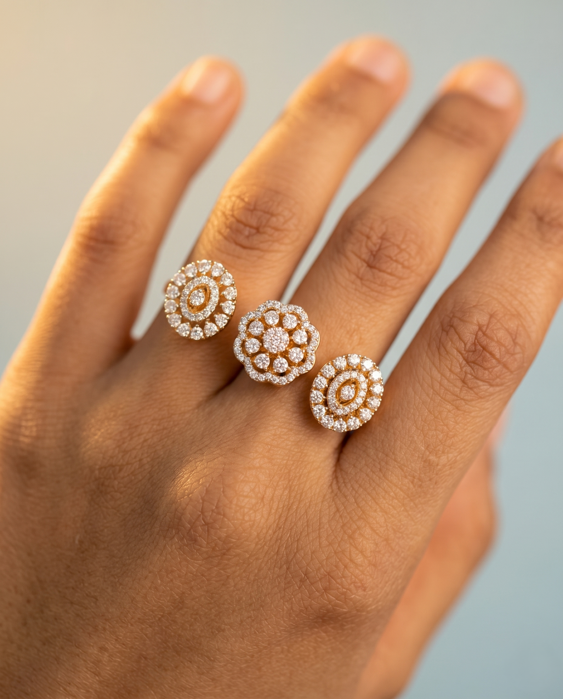 Close-up of a hand wearing two diamond stud earrings on a neutral background