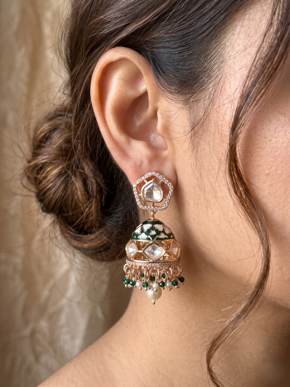 Close-up of a person wearing an ornate earring with a beige background