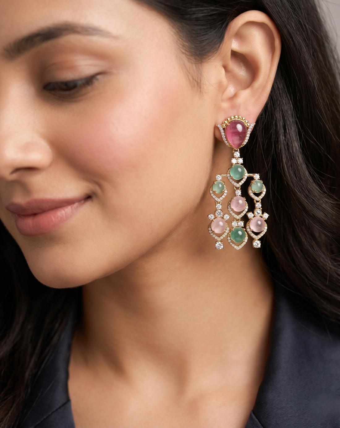 Close-up of a woman wearing a colorful earring with gemstones.