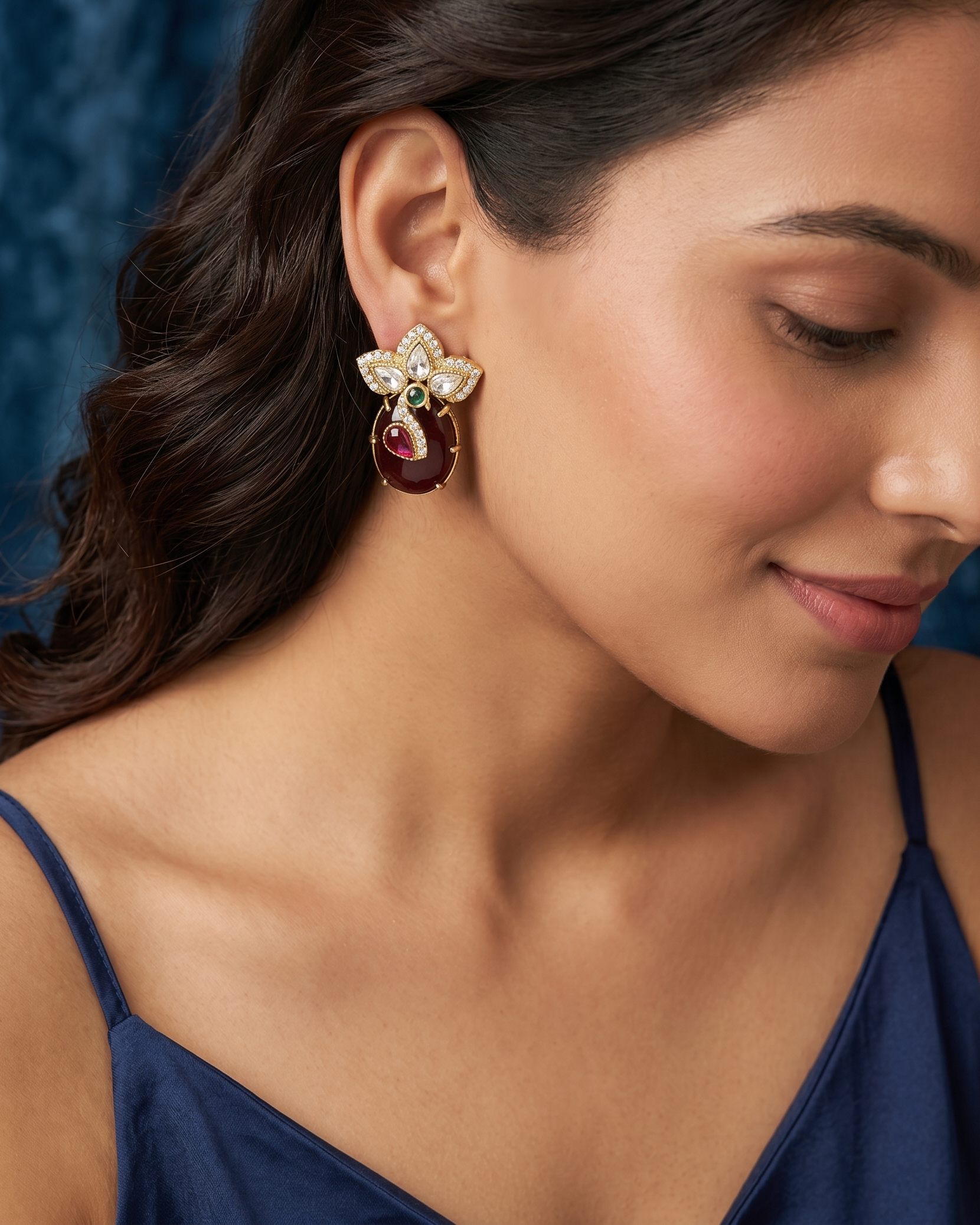 Close-up of a woman wearing a decorative earring with a blue background