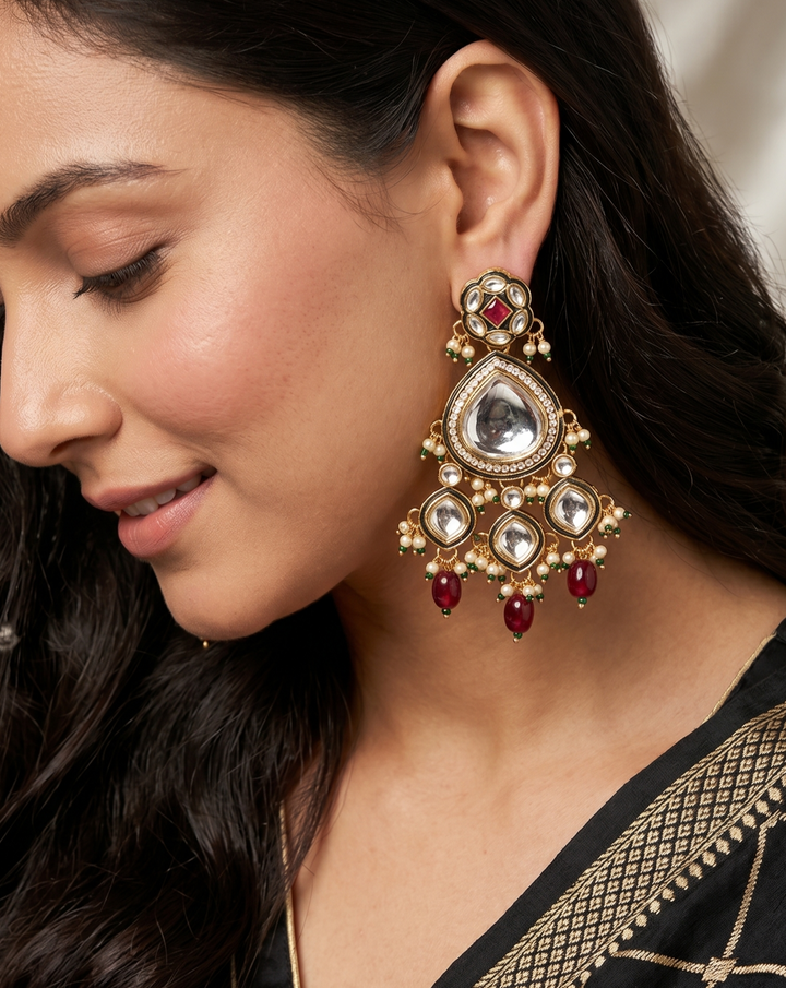 Close-up of a woman wearing a decorative earring with red stones.