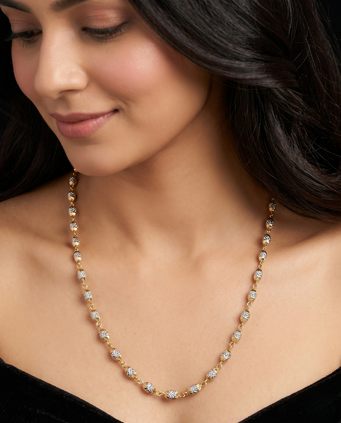 Close-up of a woman wearing a gold and diamond necklace.