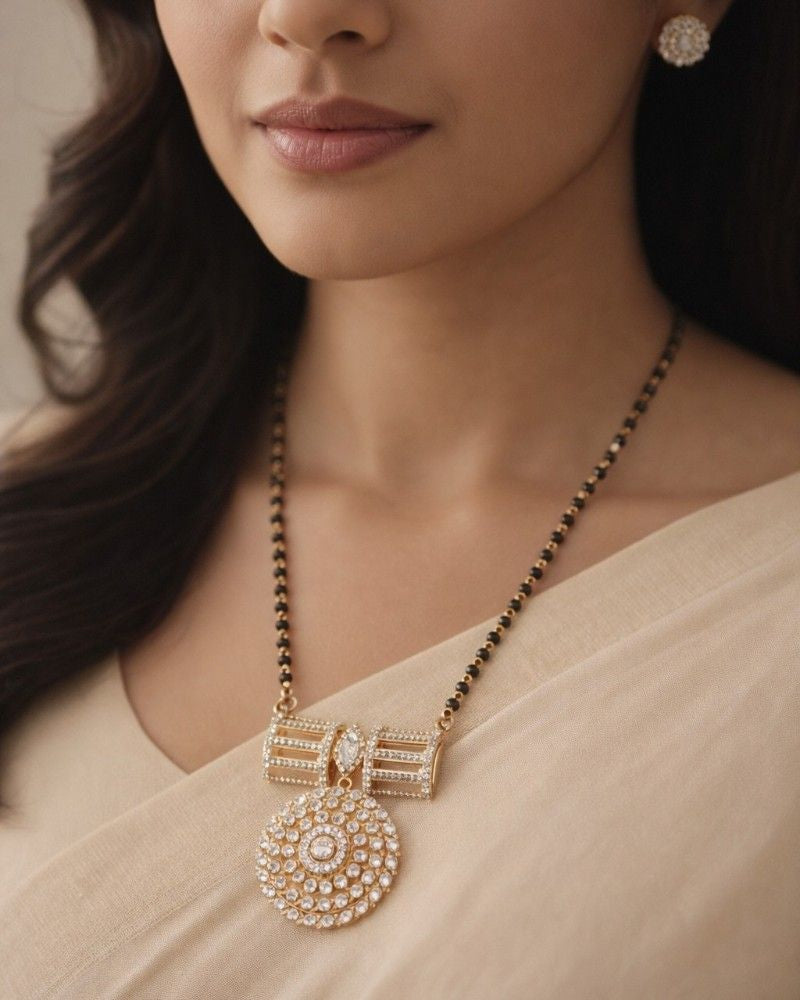 Close-up of a woman wearing a gold necklace with a large pendant.