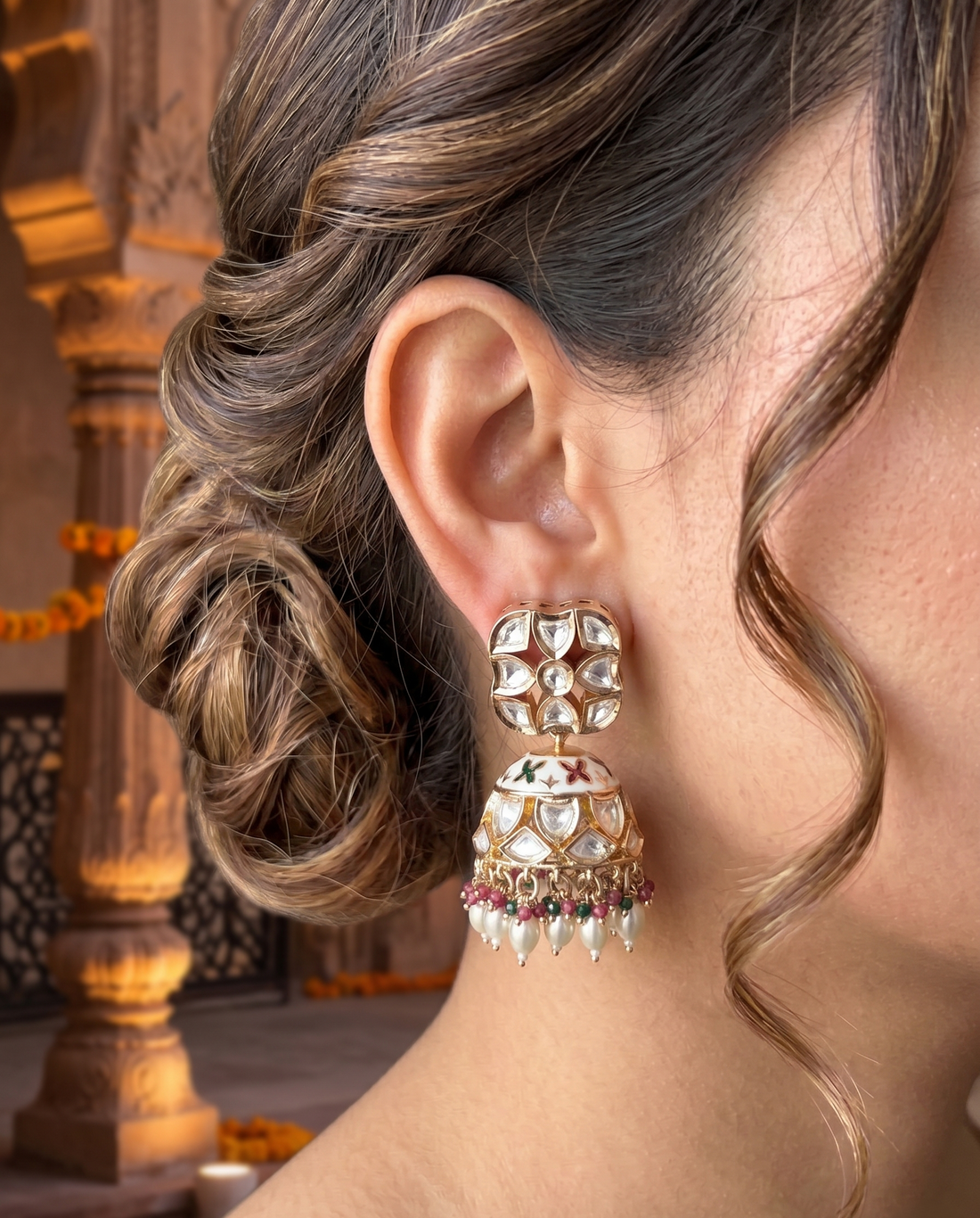 Close-up of a woman wearing a pair of ornate earrings with a blurred background