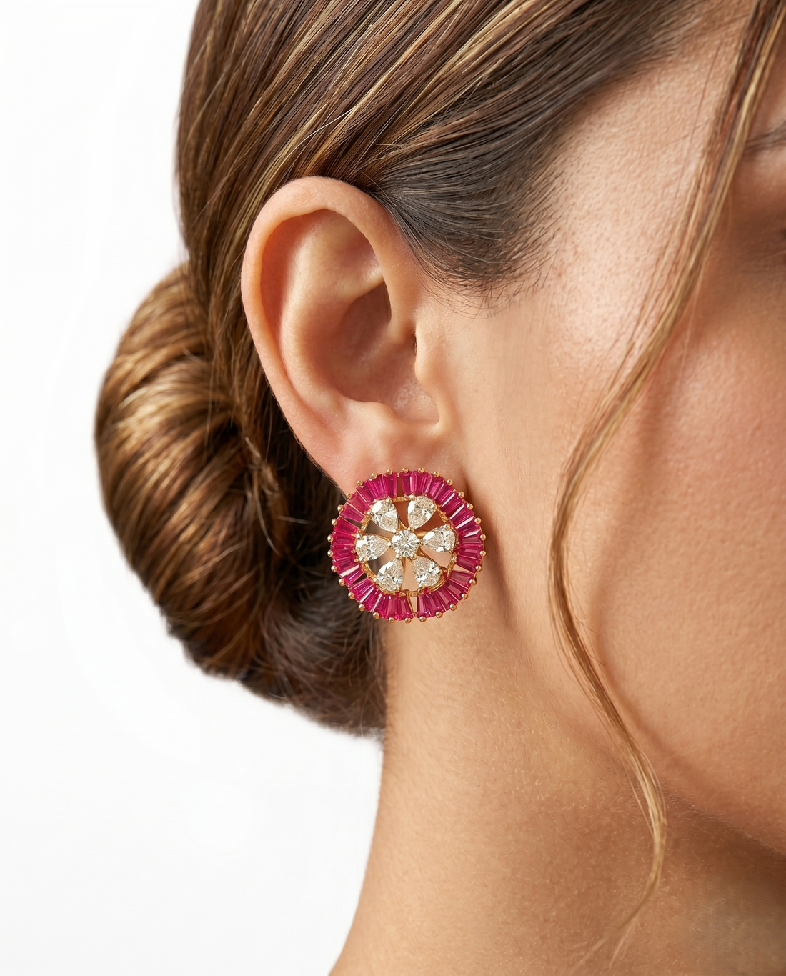 Close-up of a woman wearing a pink and gold earring with a blurred background