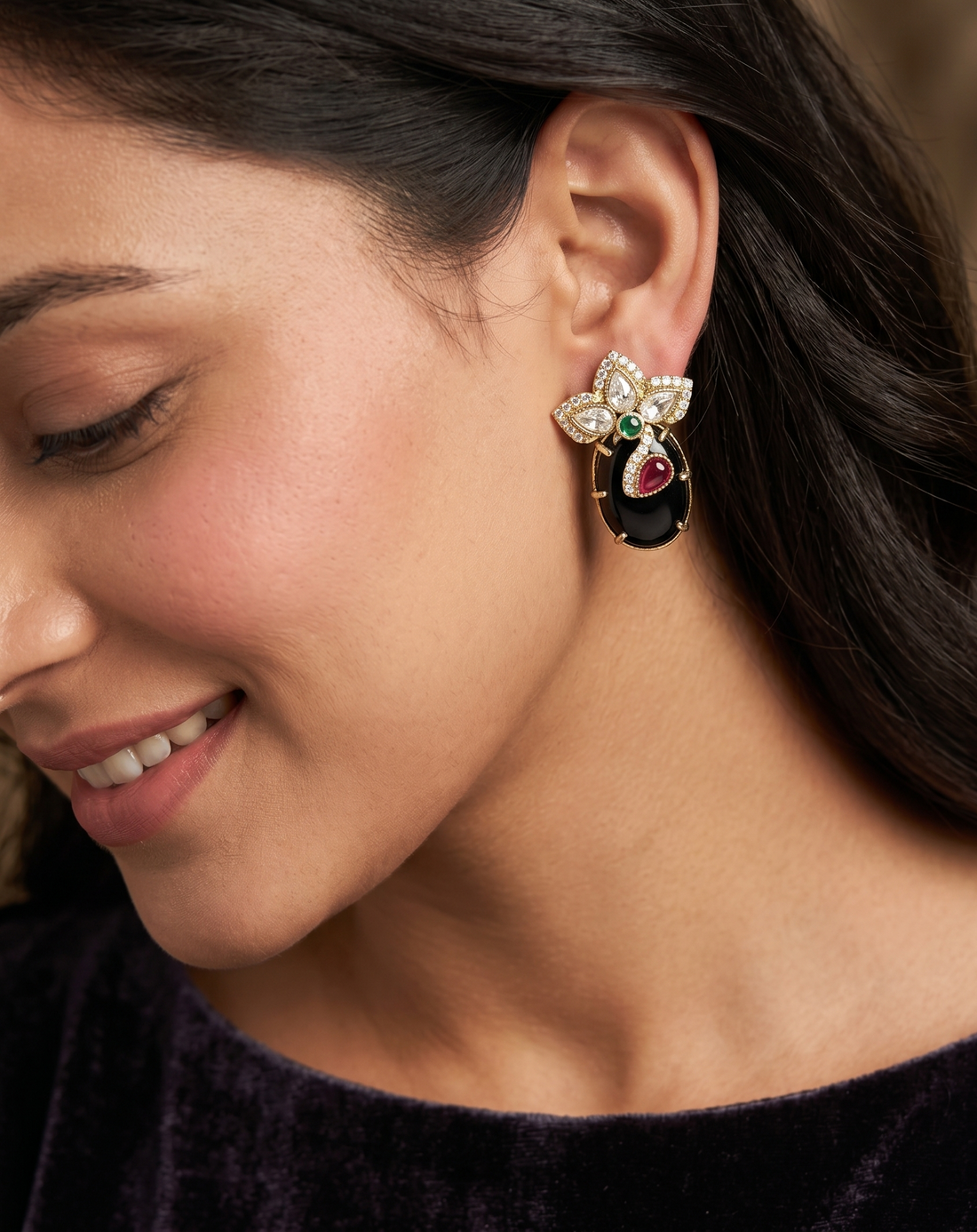 Close-up of a woman wearing an ornate earring with a dark background
