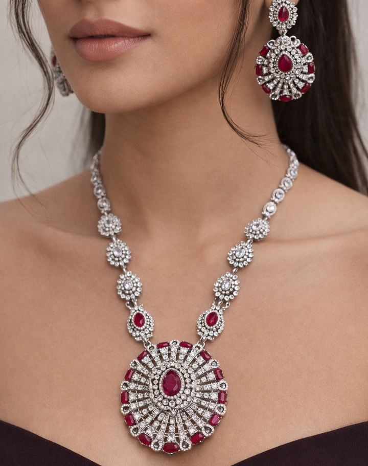 ornate silver necklace with red gemstones.