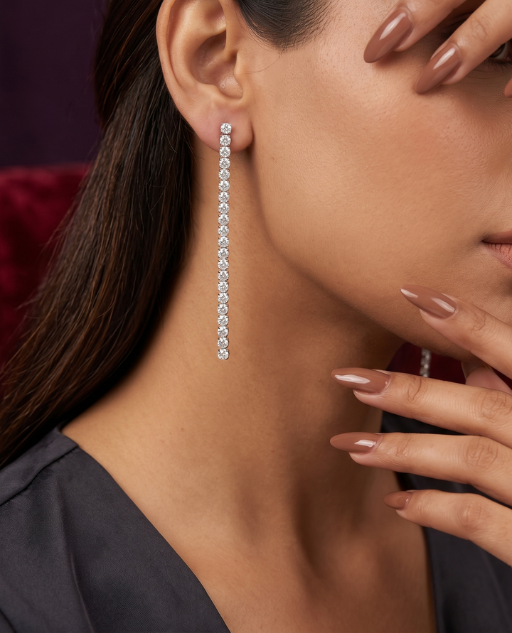 Close-up of a woman wearing diamond earrings with a blurred background