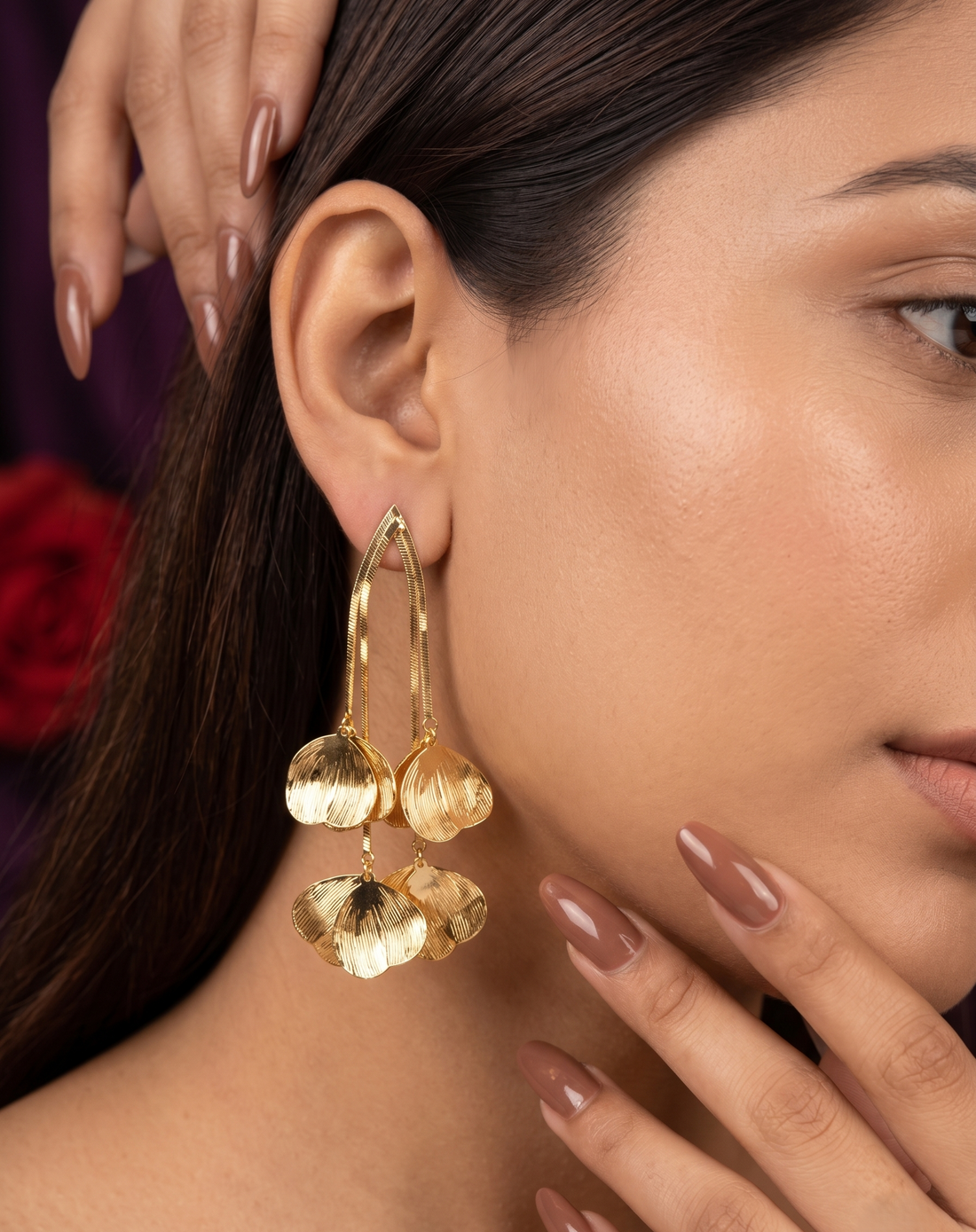 Close-up of a woman wearing gold earrings with a blurred background