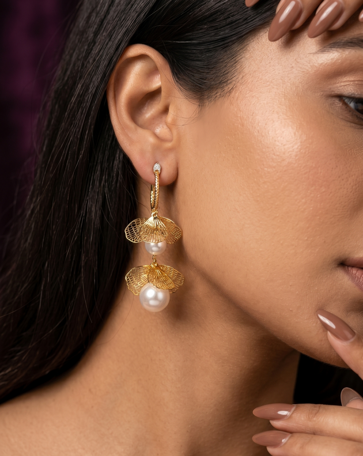 Close-up of a woman wearing gold earrings with pearls.