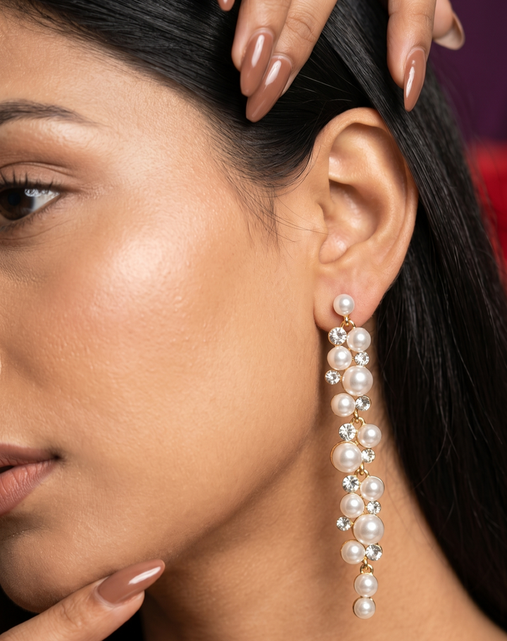 Close-up of a woman wearing pearl earrings with a blurred background