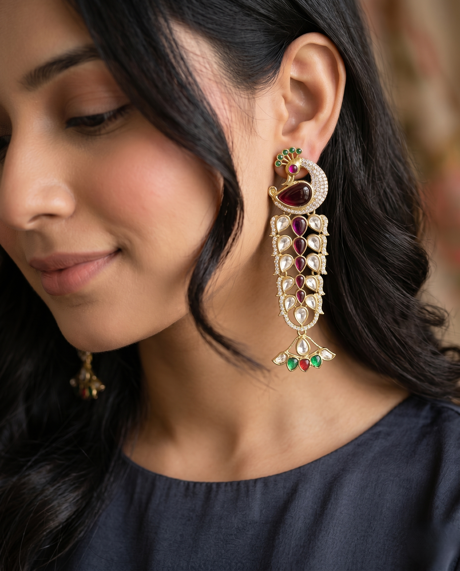 Close-up of woman wearing ornate earrings with gemstones.