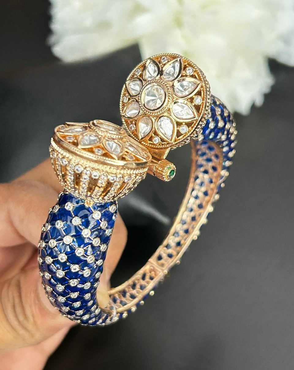 Decorative blue and gold bangles with gemstones on a dark background