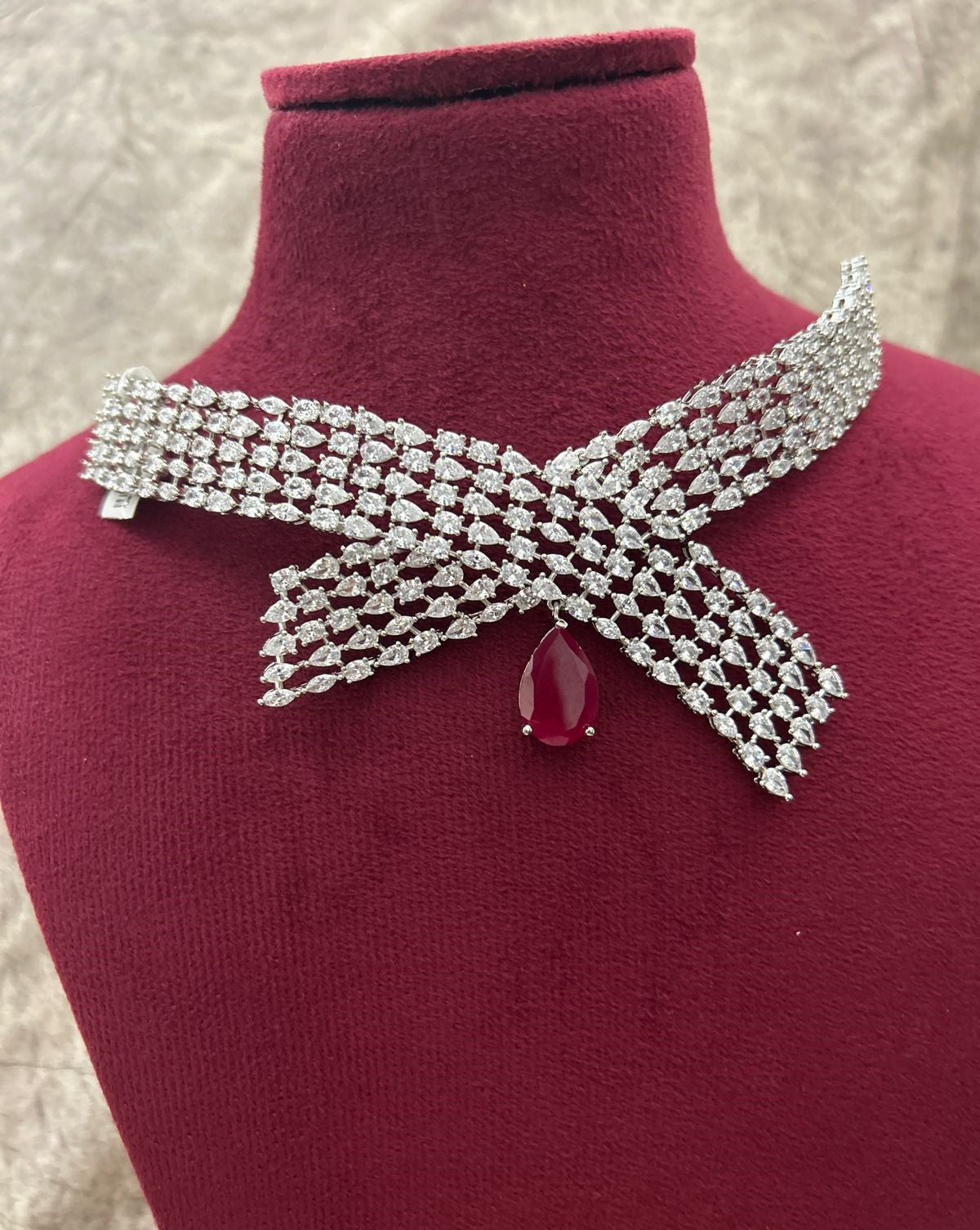 Decorative brooch with gemstone on a mannequin bust against a neutral background