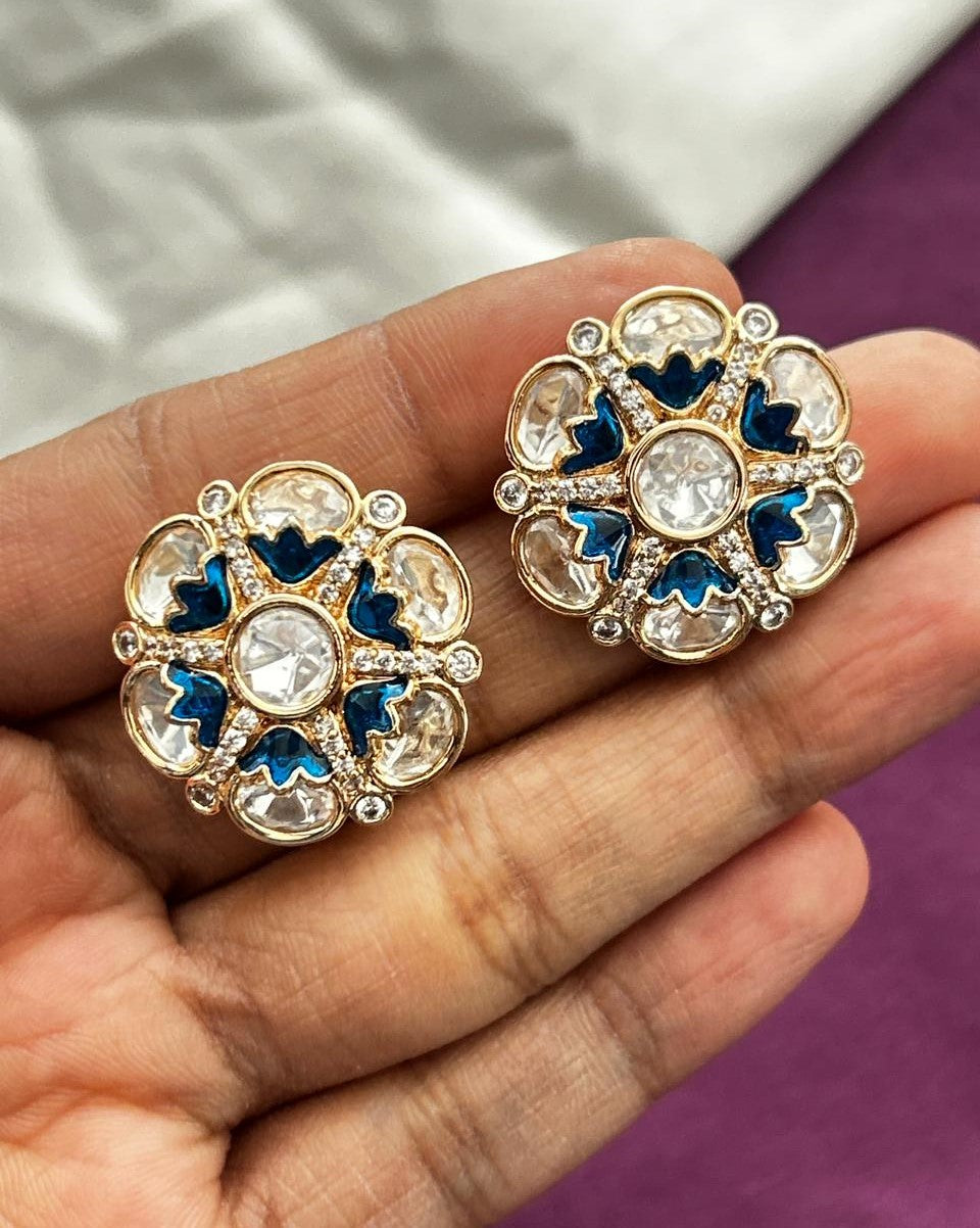 Decorative earrings held in a hand with a blurred background