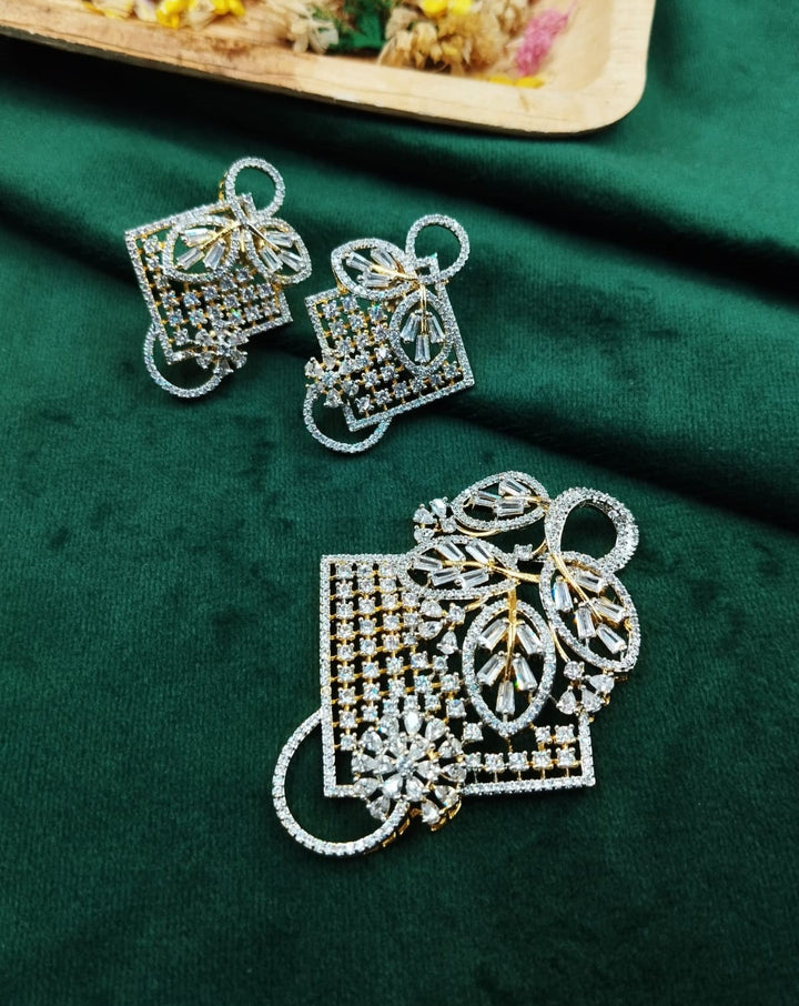 Decorative earrings with leaf design on a green fabric background