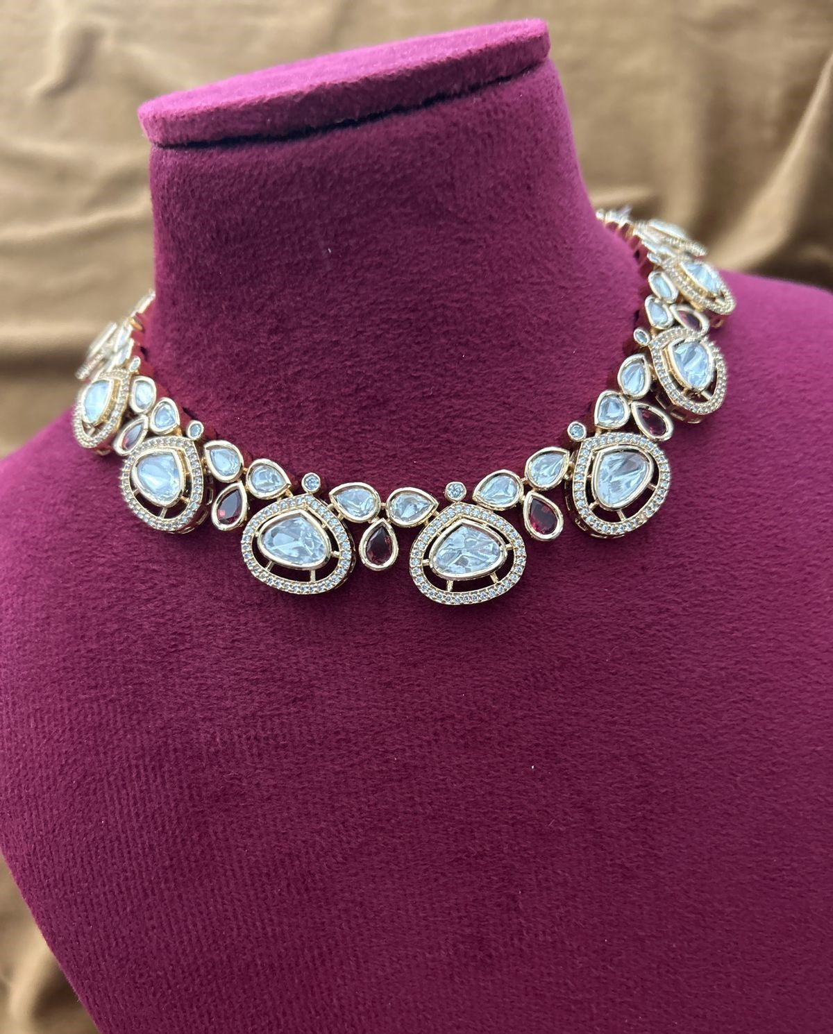 Elegant bridal adornment showcasing ivory kundan styling with deep red highlights