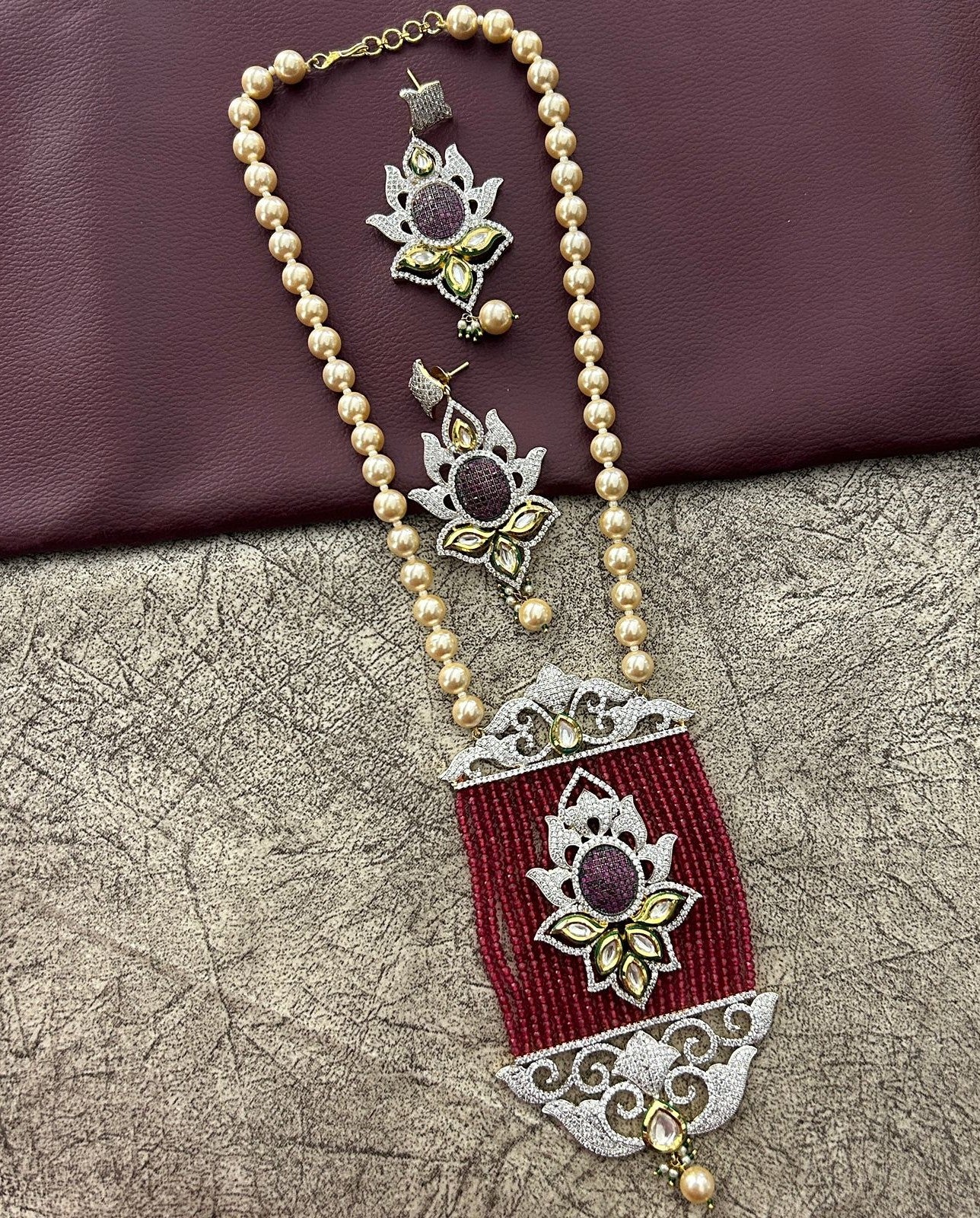 Decorative necklace with maroon pendant and pearl chain 
