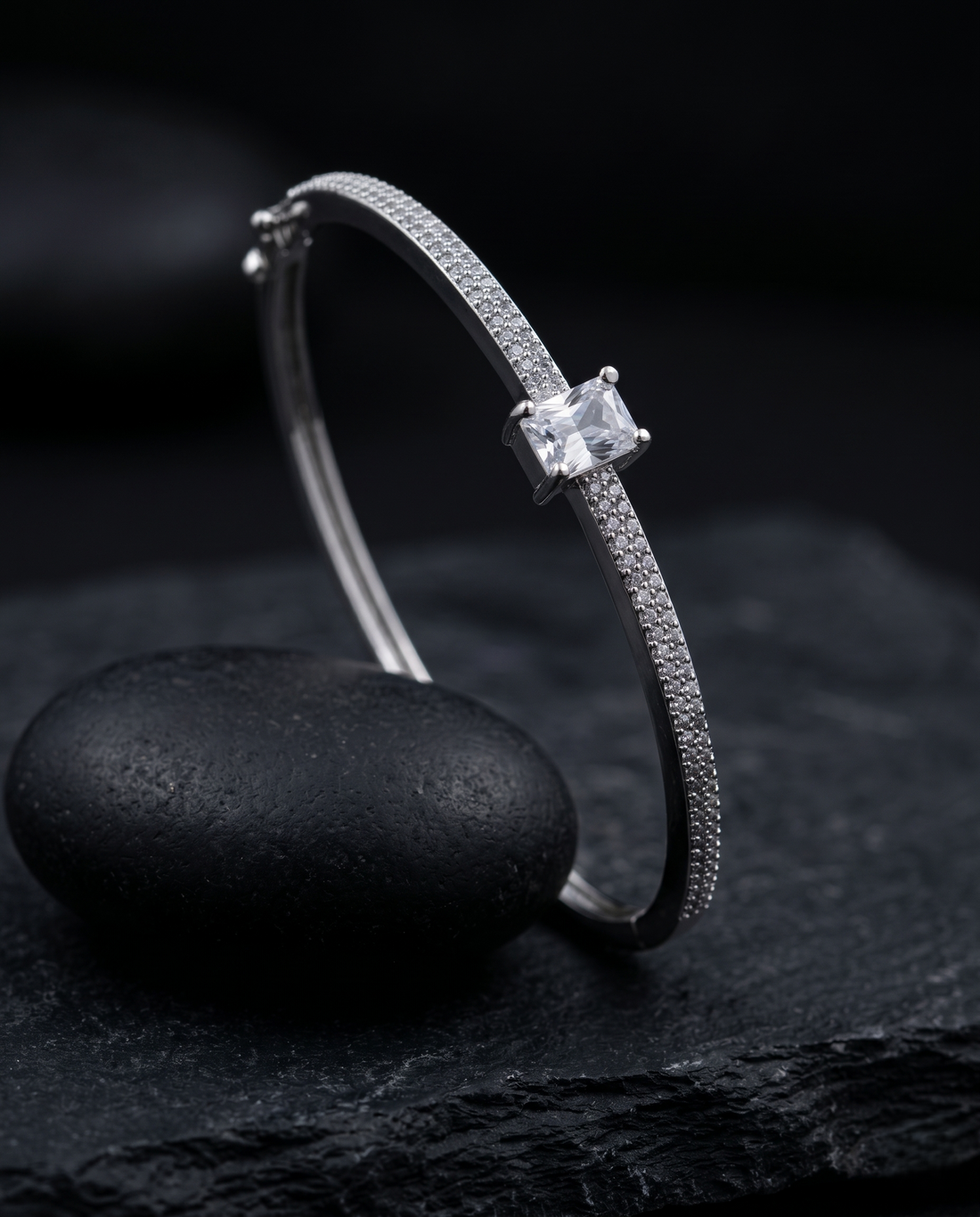 Silver bracelet with a diamond on a dark stone surface
