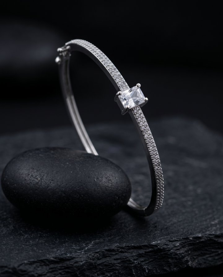 Silver bracelet with a diamond on a dark stone surface