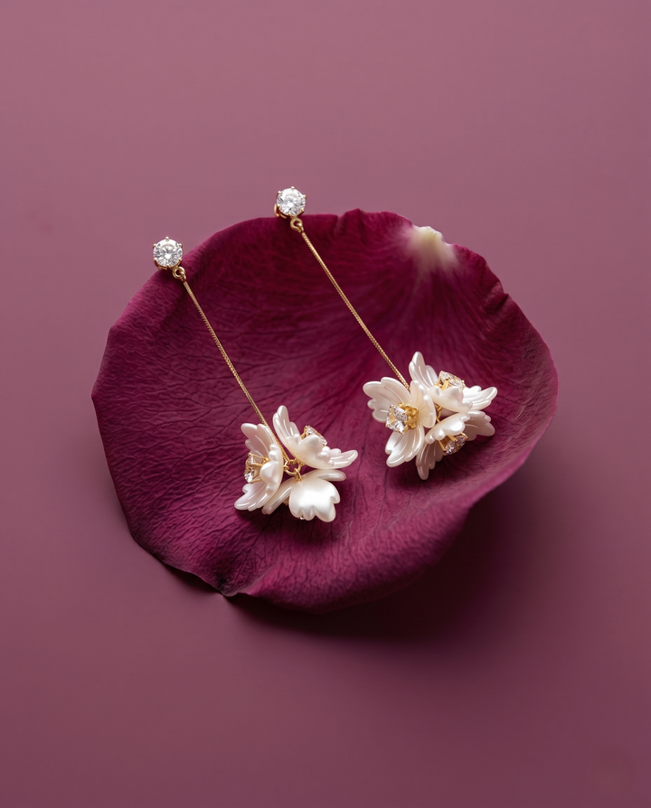 Floral earrings on a purple petal with a purple background