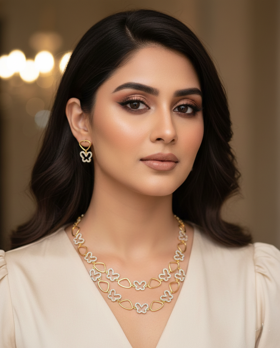 Woman wearing a gold necklace and earrings with a blurred background