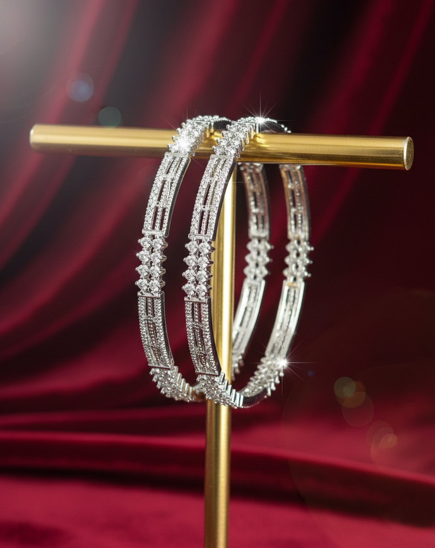 Silver hoop earrings on a gold stand against a red curtain background